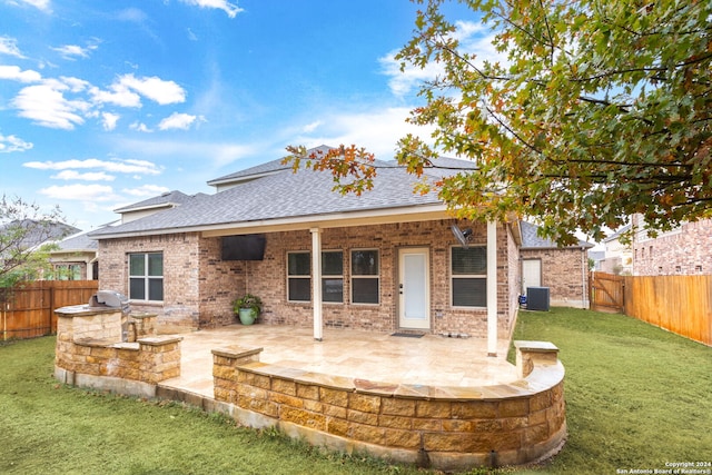 rear view of property featuring a lawn, area for grilling, a patio, and central AC