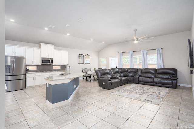 living room with ceiling fan, light tile patterned flooring, lofted ceiling, and sink