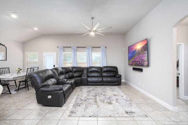 living room with ceiling fan, light tile patterned floors, and vaulted ceiling