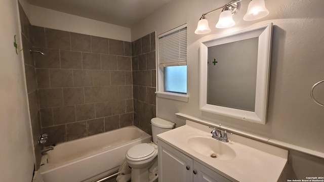 full bathroom with vanity, tiled shower / bath combo, and toilet