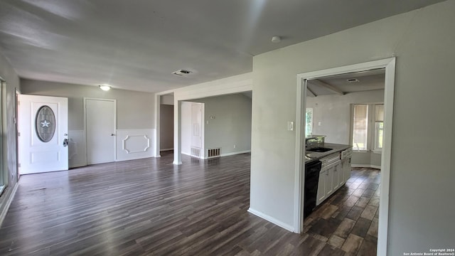 kitchen with sink, dark hardwood / wood-style flooring, white cabinets, and black dishwasher