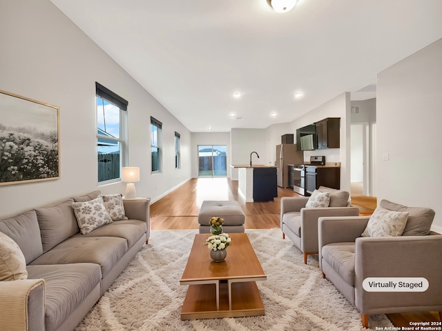 living room with light hardwood / wood-style flooring and sink