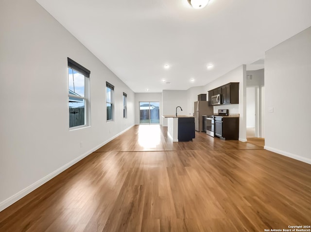 unfurnished living room featuring hardwood / wood-style floors and sink