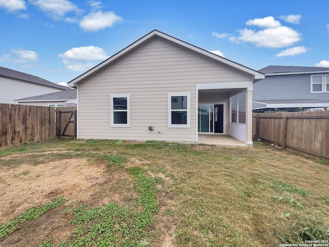 rear view of house featuring a lawn and a patio area