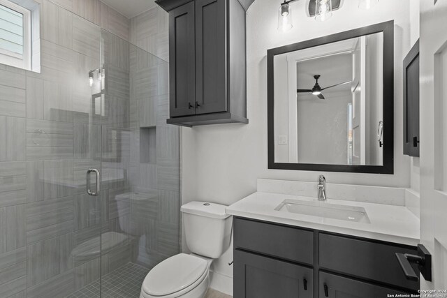 bathroom with toilet, ceiling fan, an enclosed shower, and vanity