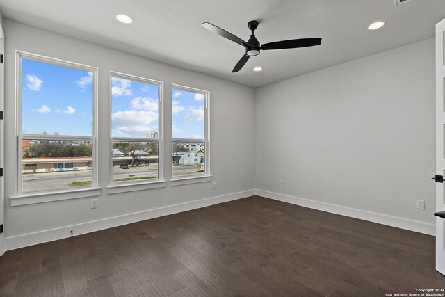 unfurnished room with ceiling fan and dark wood-type flooring