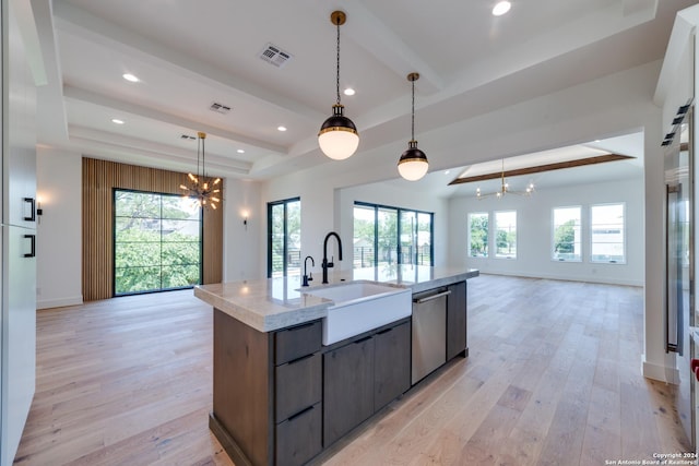 kitchen featuring stainless steel dishwasher, sink, light hardwood / wood-style flooring, a chandelier, and plenty of natural light