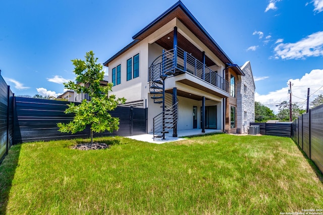 rear view of property with a yard, a balcony, a patio, and cooling unit