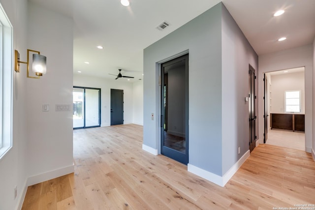 corridor featuring a healthy amount of sunlight and light wood-type flooring