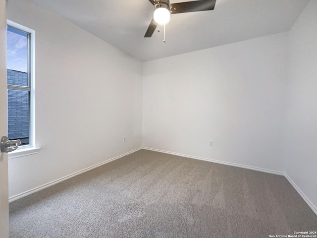 carpeted spare room with ceiling fan