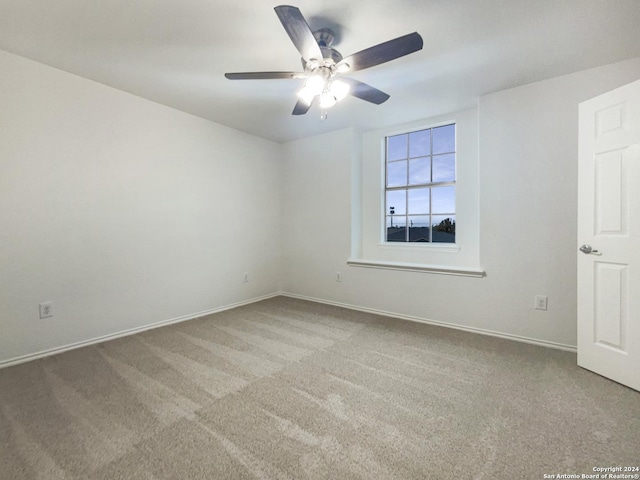 carpeted empty room featuring ceiling fan