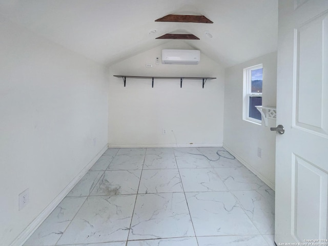 unfurnished room featuring a wall mounted AC and lofted ceiling