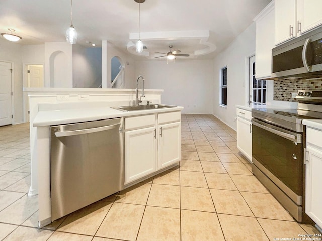 kitchen featuring ceiling fan, sink, backsplash, decorative light fixtures, and appliances with stainless steel finishes