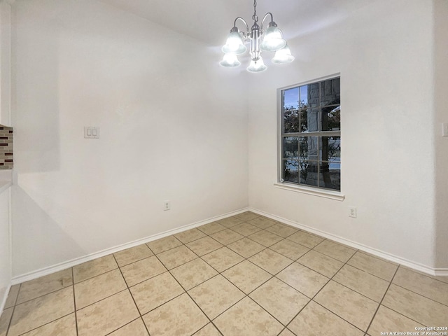 tiled empty room with a chandelier