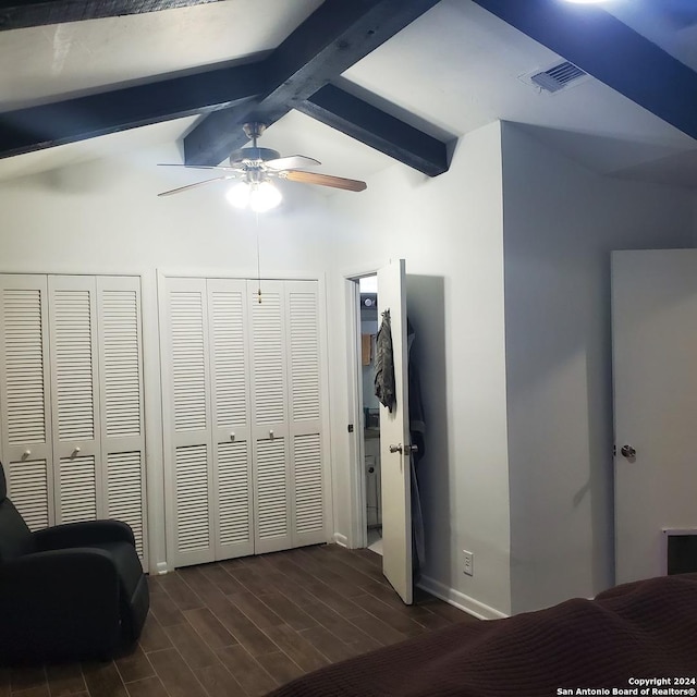 bedroom featuring vaulted ceiling with beams, ceiling fan, dark hardwood / wood-style floors, and multiple closets