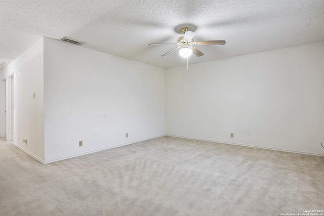 carpeted empty room with ceiling fan and a textured ceiling