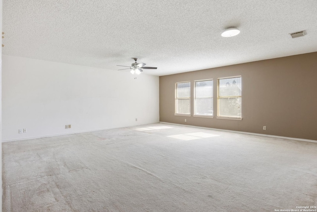 carpeted empty room featuring ceiling fan and a textured ceiling