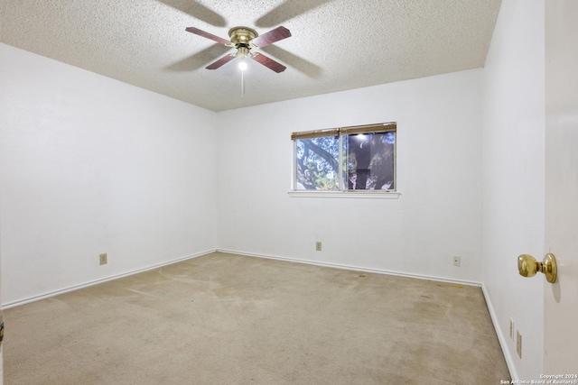 carpeted spare room featuring ceiling fan and a textured ceiling