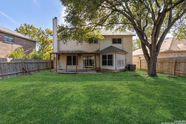 rear view of house featuring a yard, cooling unit, and a patio area