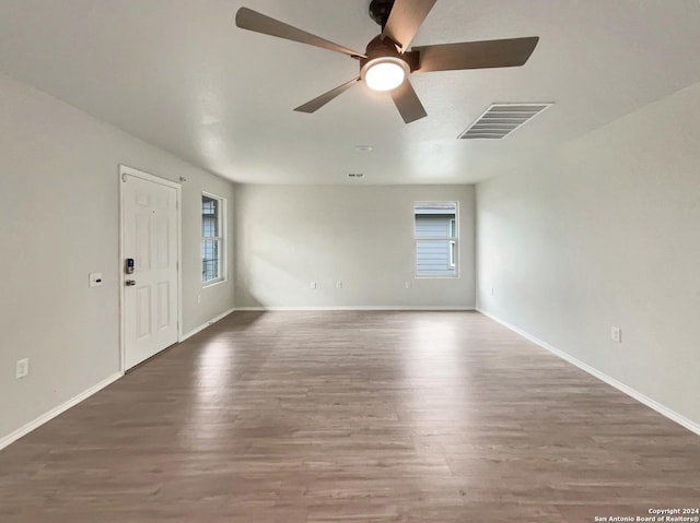 empty room featuring hardwood / wood-style flooring, a wealth of natural light, and ceiling fan