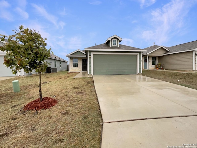 ranch-style home with central AC unit, a garage, and a front lawn