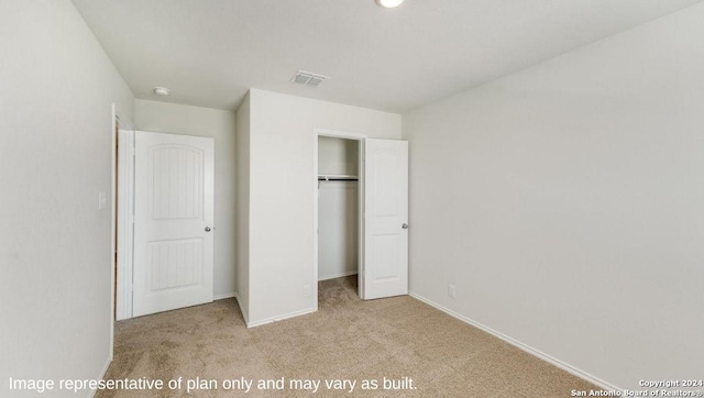 unfurnished bedroom with light carpet and a closet