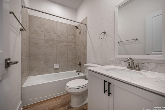 full bathroom featuring wood-type flooring, vanity, toilet, and tiled shower / bath