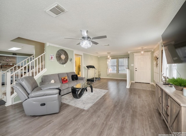 living room with crown molding, ceiling fan, a textured ceiling, and hardwood / wood-style flooring