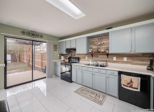 kitchen featuring sink, tasteful backsplash, a textured ceiling, light tile patterned floors, and black appliances