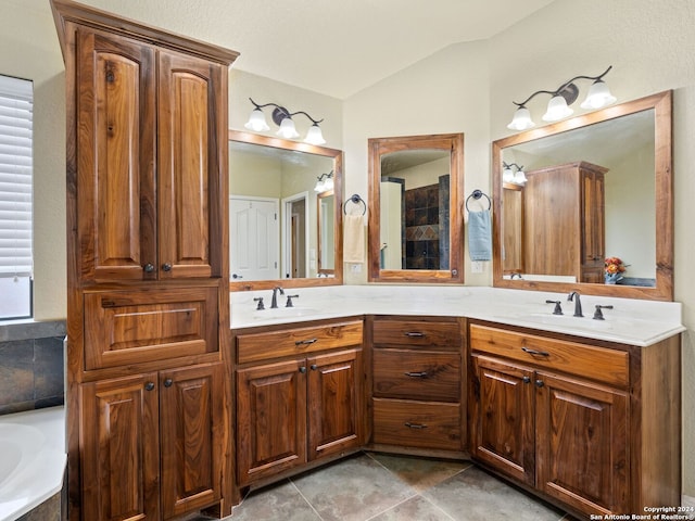 bathroom featuring tile patterned floors, vanity, a bathtub, and lofted ceiling