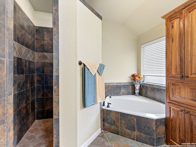 bathroom with tile patterned flooring, separate shower and tub, and lofted ceiling