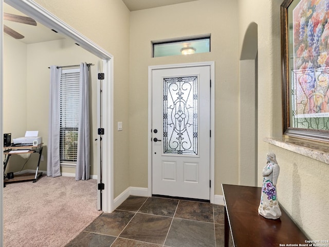 entryway featuring dark carpet and ceiling fan