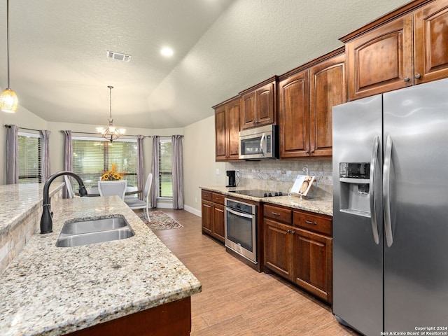 kitchen featuring appliances with stainless steel finishes, vaulted ceiling, pendant lighting, and sink