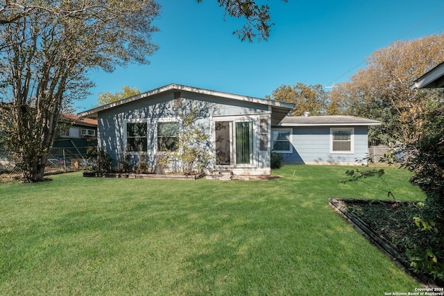 rear view of property with a yard