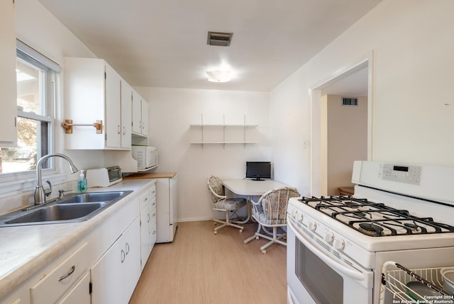 kitchen featuring light wood-type flooring, white appliances, white cabinetry, and sink