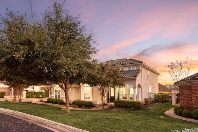 mediterranean / spanish-style home featuring a lawn