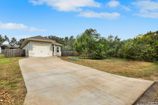 exterior space featuring a front lawn, central AC unit, and a garage