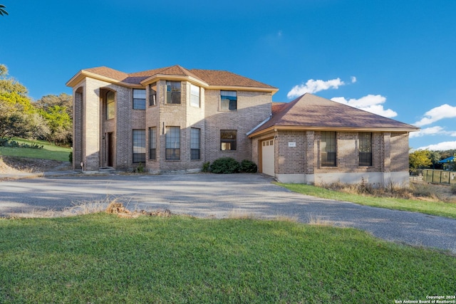 view of front of property with a front yard and a garage