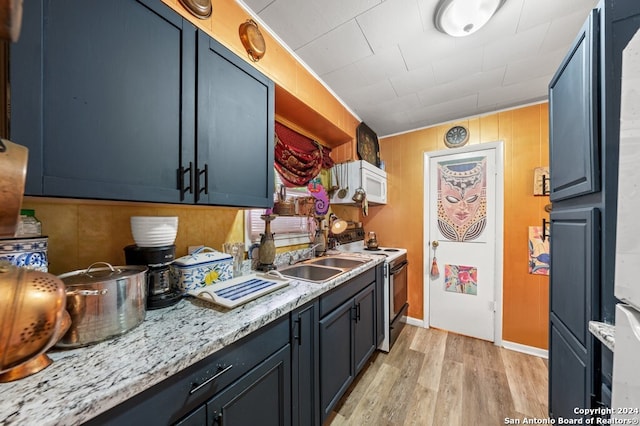 kitchen featuring light wood-type flooring, blue cabinets, stainless steel range with electric stovetop, and sink