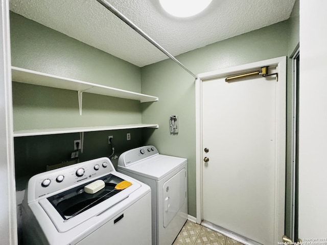 laundry area featuring washer and clothes dryer and a textured ceiling