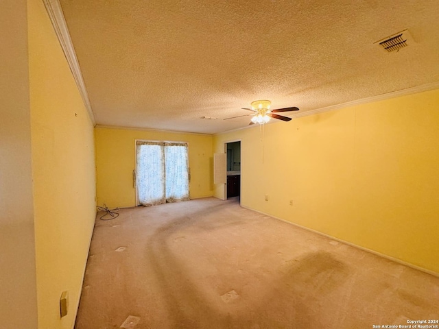 carpeted empty room featuring crown molding, ceiling fan, and a textured ceiling