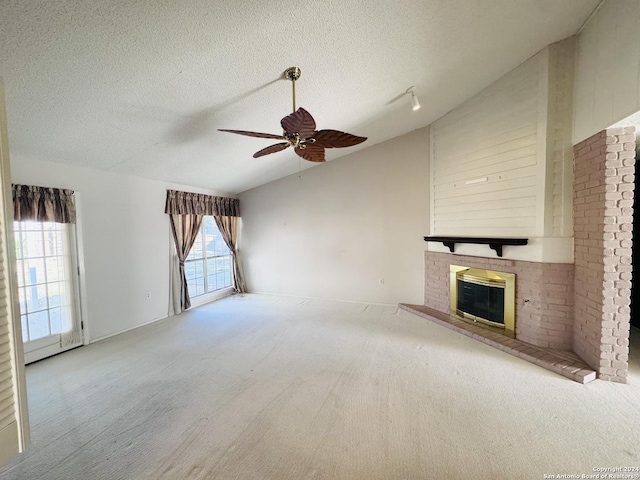 unfurnished living room featuring carpet flooring, a textured ceiling, vaulted ceiling, ceiling fan, and a fireplace