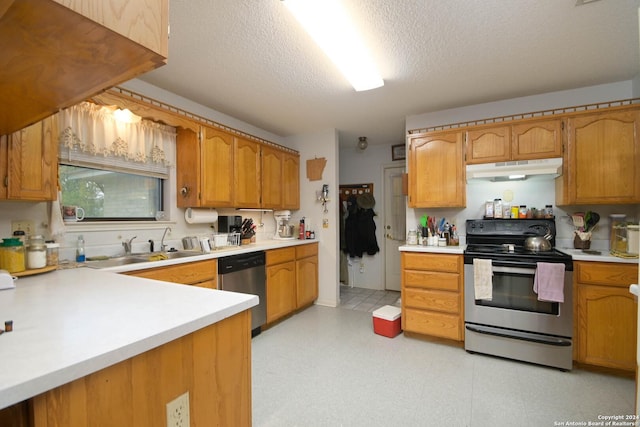 kitchen with a textured ceiling, sink, and stainless steel appliances