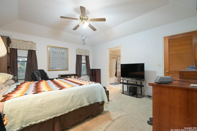 bedroom featuring carpet, a textured ceiling, a tray ceiling, and ceiling fan