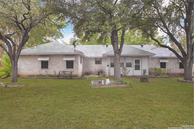 rear view of property featuring a lawn