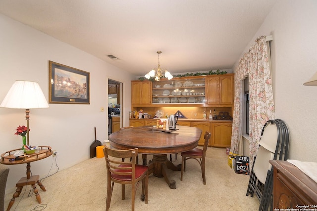 dining space featuring a notable chandelier and light carpet