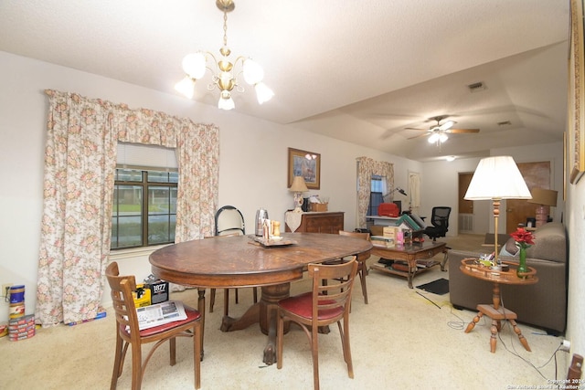 dining space with carpet and ceiling fan with notable chandelier