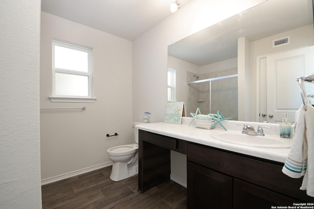 bathroom with hardwood / wood-style flooring, vanity, toilet, and an enclosed shower