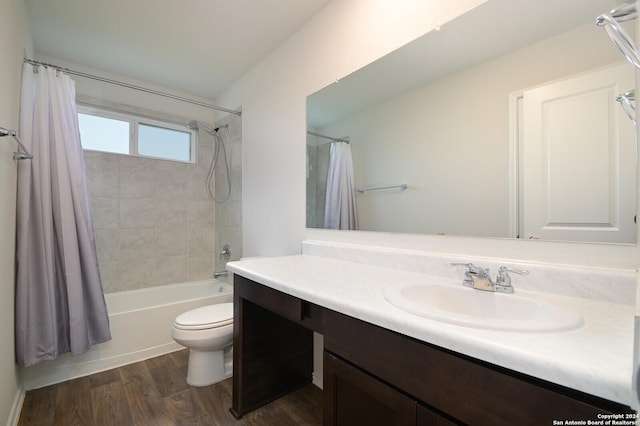 full bathroom featuring hardwood / wood-style floors, vanity, shower / tub combo, and toilet