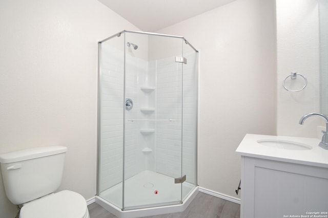 bathroom featuring vanity, hardwood / wood-style flooring, toilet, and walk in shower